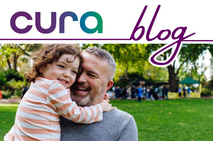 Father smiling holding his happy daughter in a park