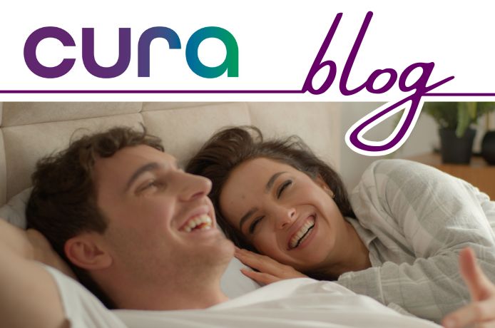 A man and woman giggling in bed. Sex and Life Insurance, Critical Illness Cover and Income Protection.